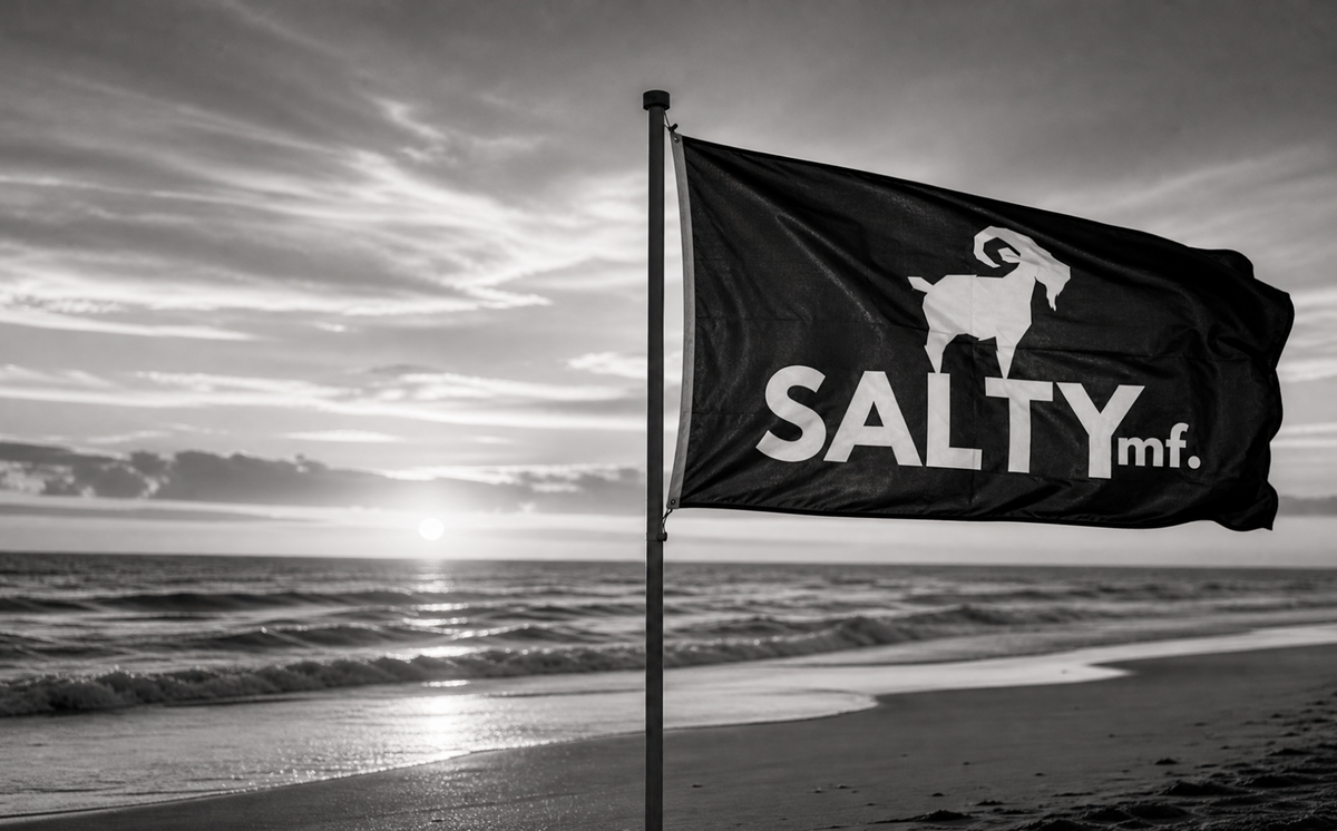 A SALTYmf goat flag flying over the beach at sunrise