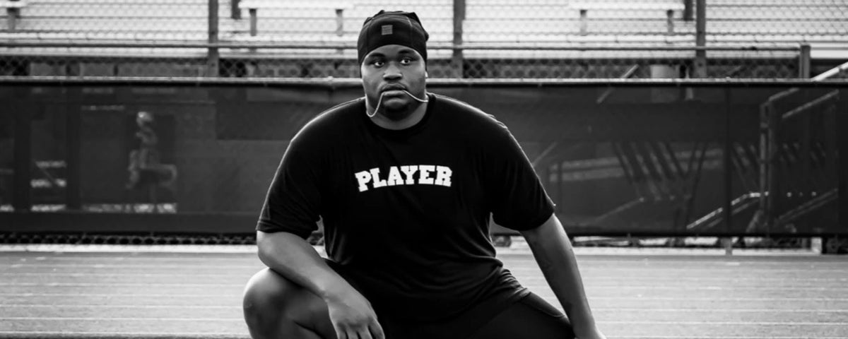 A SALTYmf athlete on the track in a PLAYER tee