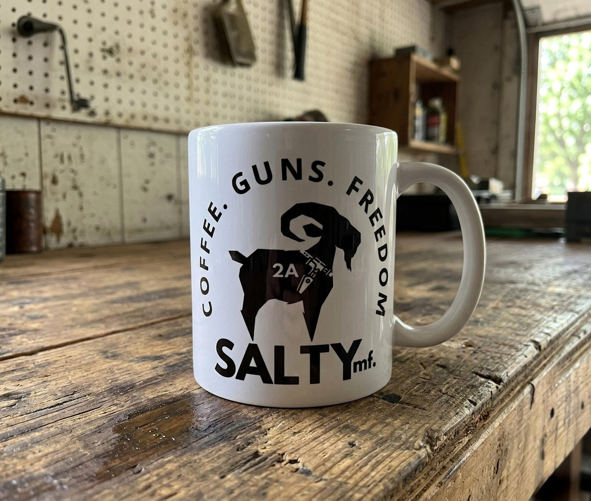 SALTYmf Coffee Guns Freedom mug on a workshop bench