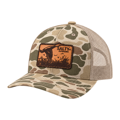 SALTYmf Leather Duck Hunt Patch Trucker in Harvest Duck Camo, three quarter view with the laser-etched leather duck patch